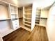 Bright walk-in closet boasts ample shelving, drawers, and custom organization system on stylish floors at 6524 Senegal Palm Way, Apollo Beach, FL 33572