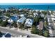 Aerial view of two-story home with a metal roof and community near the ocean at 704 Gladiolus St, Anna Maria, FL 34216