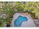 Aerial view of a backyard featuring a pool, patio, lush landscaping, and recreational space for outdoor enjoyment at 704 Gladiolus St, Anna Maria, FL 34216
