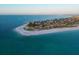 Breathtaking aerial shot of an oceanfront community with beautiful sandy beaches and clear blue waters at 704 Gladiolus St, Anna Maria, FL 34216