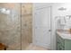 Bathroom featuring a tiled shower, vanity with granite countertops, and a white door at 704 Gladiolus St, Anna Maria, FL 34216