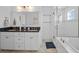 Well lit bathroom with double vanity, soaking tub, and glass enclosed shower at 704 Gladiolus St, Anna Maria, FL 34216