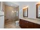 Bathroom featuring a tiled shower, granite vanity, and plantation shutters at 704 Gladiolus St, Anna Maria, FL 34216