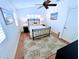 Bright bedroom with a ceiling fan, wood floors, area rug and plantation shutters at 704 Gladiolus St, Anna Maria, FL 34216