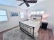 Bright bedroom with a ceiling fan, wood floors, area rug and plantation shutters at 704 Gladiolus St, Anna Maria, FL 34216