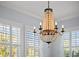 A lovely chandelier hanging in front of multiple windows with white shutters, with natural light at 704 Gladiolus St, Anna Maria, FL 34216