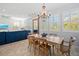 Bright dining area with a wooden table, chandelier, and lots of light shining through the many large windows at 704 Gladiolus St, Anna Maria, FL 34216