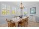 Elegant dining area featuring a rustic wooden table, matching chairs, and plantation shutters for natural light at 704 Gladiolus St, Anna Maria, FL 34216