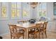 Dining room with a wooden table, seating for six, tiled floors, and many bright windows at 704 Gladiolus St, Anna Maria, FL 34216