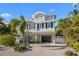 Beautiful two-story home featuring a well-manicured lawn, a garage, and charming architectural details at 704 Gladiolus St, Anna Maria, FL 34216
