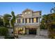 Charming two-story home with a black garage door and a landscaped yard, creating an inviting curb appeal at 704 Gladiolus St, Anna Maria, FL 34216