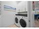 Bright laundry room features a modern washer and dryer, upper cabinets, and a dark countertop for folding at 704 Gladiolus St, Anna Maria, FL 34216