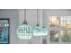 Stylish pendant lights with decorative glass shades hanging above a kitchen island, adding charm at 704 Gladiolus St, Anna Maria, FL 34216