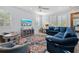Bright living room with multiple windows and a blue sectional sofa with comfortable chairs at 704 Gladiolus St, Anna Maria, FL 34216