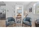 Open-concept living area with comfortable chairs and stylish decorations, plus a stairway to the upper level at 704 Gladiolus St, Anna Maria, FL 34216