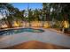 Backyard pool with lush landscaping, ample deck space, and decorative lighting at 704 Gladiolus St, Anna Maria, FL 34216