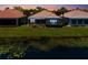 Backyard view of home overlooking the water with a screened in porch and lush green landscaping at 7164 Rue De Palisades # 5, Sarasota, FL 34238