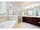 Spacious bathroom featuring a large soaking tub, glass-enclosed shower, and a double vanity at 7164 Rue De Palisades # 5, Sarasota, FL 34238