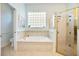 Elegant bathroom with a separate tub and shower, tile surround, and convenient toilet area at 7164 Rue De Palisades # 5, Sarasota, FL 34238