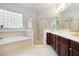 Luxurious bathroom boasts a soaking tub, walk-in shower with glass door, and dual sink vanity at 7164 Rue De Palisades # 5, Sarasota, FL 34238
