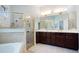 Well appointed bathroom boasts a large tub, glass-enclosed shower, and a double vanity with dark wood cabinets at 7164 Rue De Palisades # 5, Sarasota, FL 34238