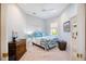 Cozy bedroom with colorful rug, dresser, and a window providing natural light, creating a serene and inviting space at 7164 Rue De Palisades # 5, Sarasota, FL 34238