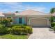 Charming home featuring a tile roof, two-car garage, manicured landscaping, and a brick-paved driveway at 7164 Rue De Palisades # 5, Sarasota, FL 34238