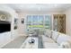 Comfortable living room with built-in shelving, a cozy sofa, a decorative glass cabinet, and shuttered window views at 7164 Rue De Palisades # 5, Sarasota, FL 34238