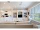 Inviting living room with custom built-ins, a ceiling fan, and large windows offering serene views of the lake at 7164 Rue De Palisades # 5, Sarasota, FL 34238