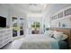 Bright main bedroom features a built-in desk, neutral walls, tray ceiling, and access to the lanai at 7164 Rue De Palisades # 5, Sarasota, FL 34238