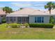 Rear exterior of a home with a screened lanai overlooking a lush lawn at 7164 Rue De Palisades # 5, Sarasota, FL 34238