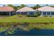 Rear exterior of a home with a screened lanai and tranquil lake views at 7164 Rue De Palisades # 5, Sarasota, FL 34238
