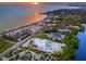 Aerial view of a modern white home with pool and beachfront access, surrounded by lush landscaping and a serene ocean at 7647 Sanderling Rd, Sarasota, FL 34242