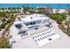 A modern white home with pool, lounge area and decorative hardscape detail in an aerial shot at 7647 Sanderling Rd, Sarasota, FL 34242