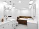 Elegant bathroom with dual sinks, modern lighting, and a luxurious soaking tub at 7647 Sanderling Rd, Sarasota, FL 34242