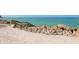 Picturesque beach access featuring wooden stairs leading to the sandy shore and turquoise water at 7647 Sanderling Rd, Sarasota, FL 34242