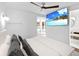 Bright bedroom featuring a ceiling fan, TV, and access to a sunlit patio at 7647 Sanderling Rd, Sarasota, FL 34242