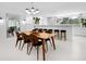 Bright open-concept dining area with modern lighting, stylish chairs, and a view of outdoor area at 7647 Sanderling Rd, Sarasota, FL 34242