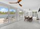 Dining area with large windows, a modern ceiling fan, and views of the outdoor patio and pool at 7647 Sanderling Rd, Sarasota, FL 34242