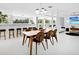 Bright open-concept dining area with modern lighting, stylish chairs, and a view of outdoor area at 7647 Sanderling Rd, Sarasota, FL 34242