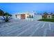 Modern home exterior showcases a unique facade, geometric landscape design, and a stylish driveway at 7647 Sanderling Rd, Sarasota, FL 34242
