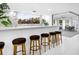 Stylish kitchen bar with stool seating, white countertops, and a pass-through window with a pool view at 7647 Sanderling Rd, Sarasota, FL 34242