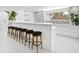 Bright kitchen bar featuring counter seating, a unique backsplash, and views of the home's spiral staircase at 7647 Sanderling Rd, Sarasota, FL 34242