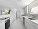 Modern white kitchen featuring stone backsplash, sleek countertops, and stainless steel appliances at 7647 Sanderling Rd, Sarasota, FL 34242