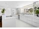 Modern, all-white kitchen boasts sleek countertops, stainless steel appliances, and a scenic view at 7647 Sanderling Rd, Sarasota, FL 34242
