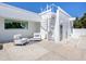 Charming outdoor patio with seating area, a spiral staircase, and lovely white rock landscaping at 7647 Sanderling Rd, Sarasota, FL 34242