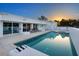 A gorgeous backyard pool reflecting the white modern architecture of the home at sunset at 7647 Sanderling Rd, Sarasota, FL 34242