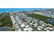 Breathtaking aerial view features the neighborhood canals near the beach and a home with a screened-in pool at 791 Saint Judes Dr N, Longboat Key, FL 34228