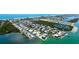 Panoramic aerial view showcases canal-front neighborhood location near the beach and the home with a screened pool at 791 Saint Judes Dr N, Longboat Key, FL 34228