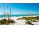 Beautiful beach with white sands, calm turquoise waters, and distant beachgoers at 791 Saint Judes Dr N, Longboat Key, FL 34228
